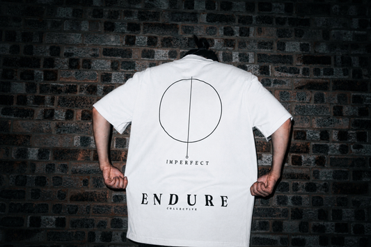 Model wearing White Imperfect Circle oversized graphic T-shirt with ENDURE COLLECTIVE back print