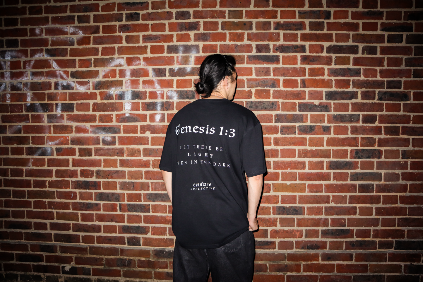 Black Genesis 1:3 oversized T-shirt back fit photo featuring white scripture-inspired print and faith-based streetwear design by ENDURE COLLECTIVE.