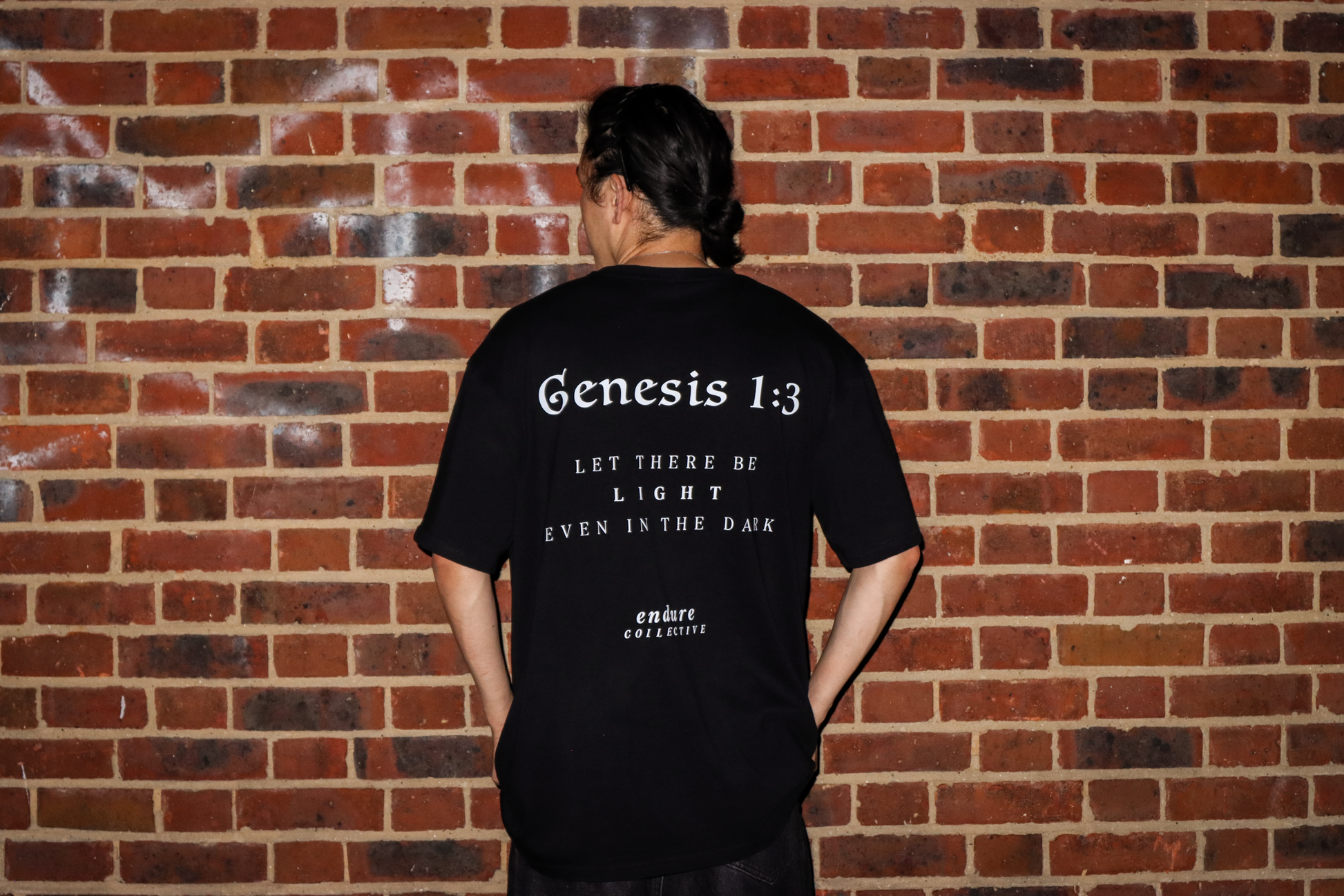 Black Genesis 1:3 oversized T-shirt back print photo featuring scripture-inspired “Let there be light even in the dark” design by ENDURE COLLECTIVE.