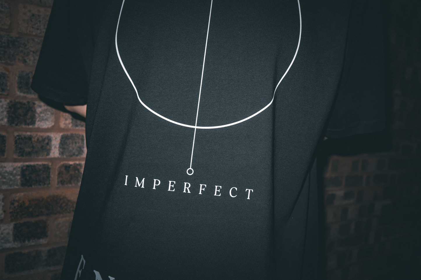 Close-up of Imperfect Circle back graphic on ENDURE COLLECTIVE oversized T-shirt