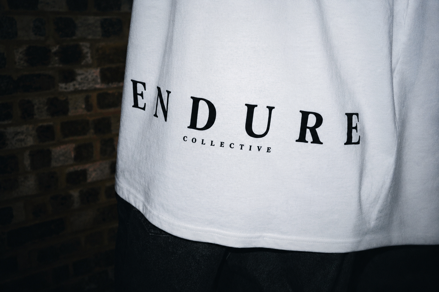 White ENDURE COLLECTIVE oversized graphic T-shirt back logo detail with black print