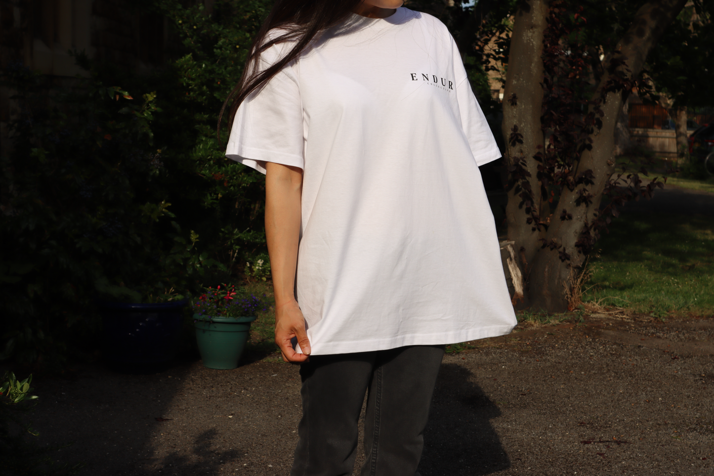 White Genesis 1:3 oversized T-shirt front fit photo, featuring ENDURE COLLECTIVE chest logo and faith-based streetwear design.